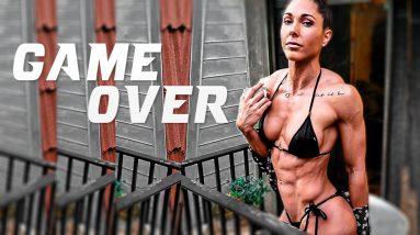 woman showing her muscles in a bikini outside with text GAME OVER