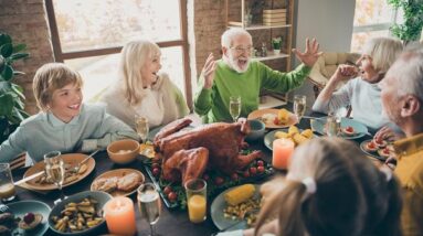 A family laughing together at their Thanksgiving dinner.