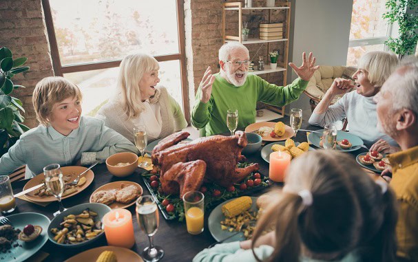 A family laughing together at their Thanksgiving dinner.