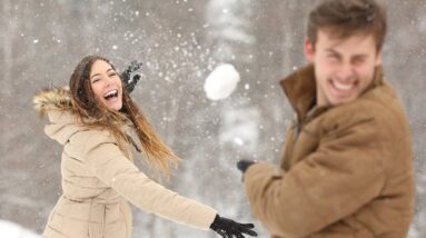 A couple having fun with a snowball fight.