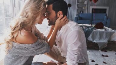 A couple sitting and hugging with their foreheads lovingly against each other.