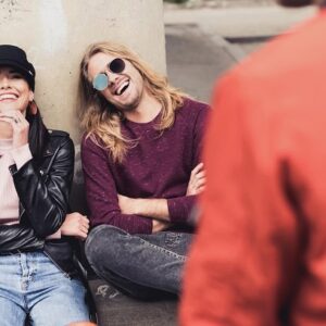 Friends laughing together while sitting outside.