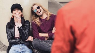 Friends laughing together while sitting outside.