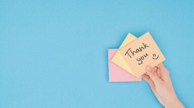 A hand holding a post-it that says: Thank you