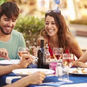 Happy people sharing a meal outside in the warmth.