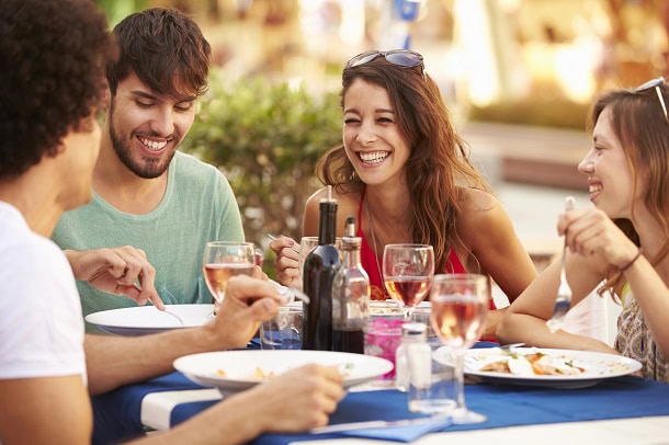 Happy people sharing a meal outside in the warmth.