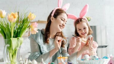 Mother and daughter having fun while painting Easter eggs.