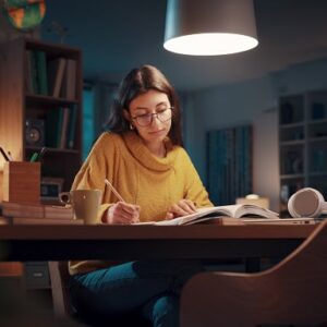 A woman focusing on studying in the evening.