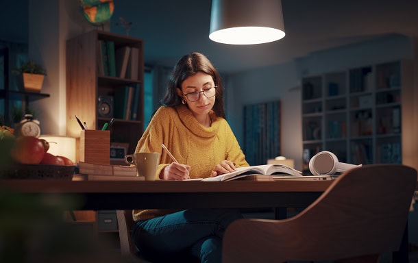 A woman focusing on studying in the evening.