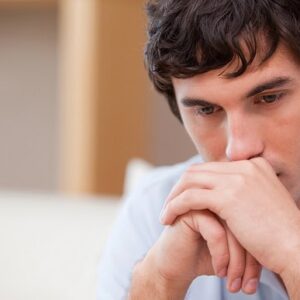 A man sitting down and looking thoughtful.