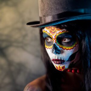 A young woman with a high hat and a her face painted for Halloween.