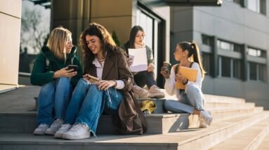 Girls having fun while sitting on the stairs leading to the school.