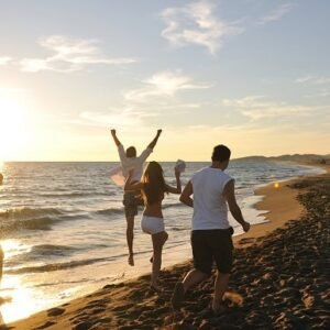Friends running on the beach during a summer sunset.