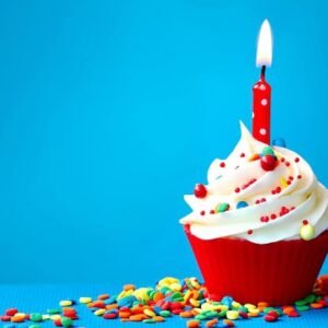 A cupcake with a single lit candle in the middle of it.