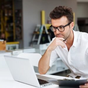 A focused and motivated man working on his laptop.