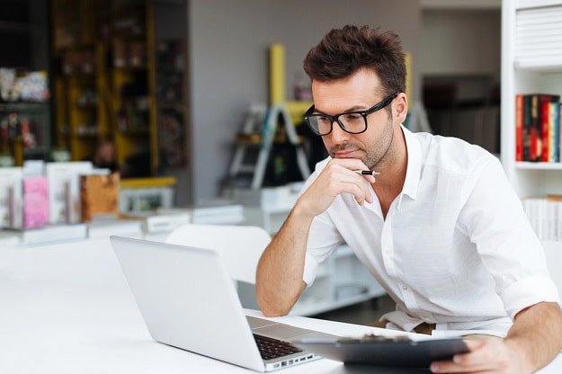 A focused and motivated man working on his laptop.