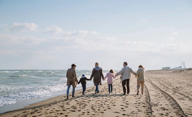 A happy family walking on a beach.
